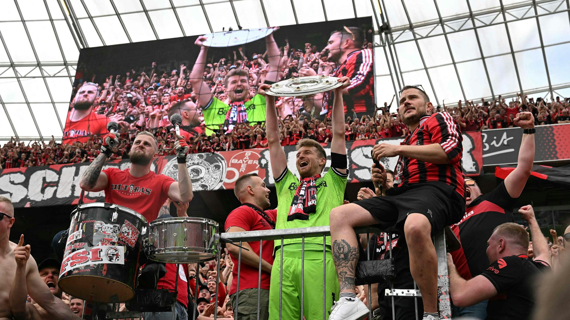 Bayer Leverkusen's Finnish goalkeeper #01 Lukas Hradecky celebrates with the Bundesliga trophy amongst the fans after the German first division Bundesliga football match between Bayer 04 Leverkusen and FC Augsburg in Leverkusen, western Germany on May 18, 2024. (Photo by INA FASSBENDER / AFP) / DFL REGULATIONS PROHIBIT ANY USE OF PHOTOGRAPHS AS IMAGE SEQUENCES AND/OR QUASI-VIDEO