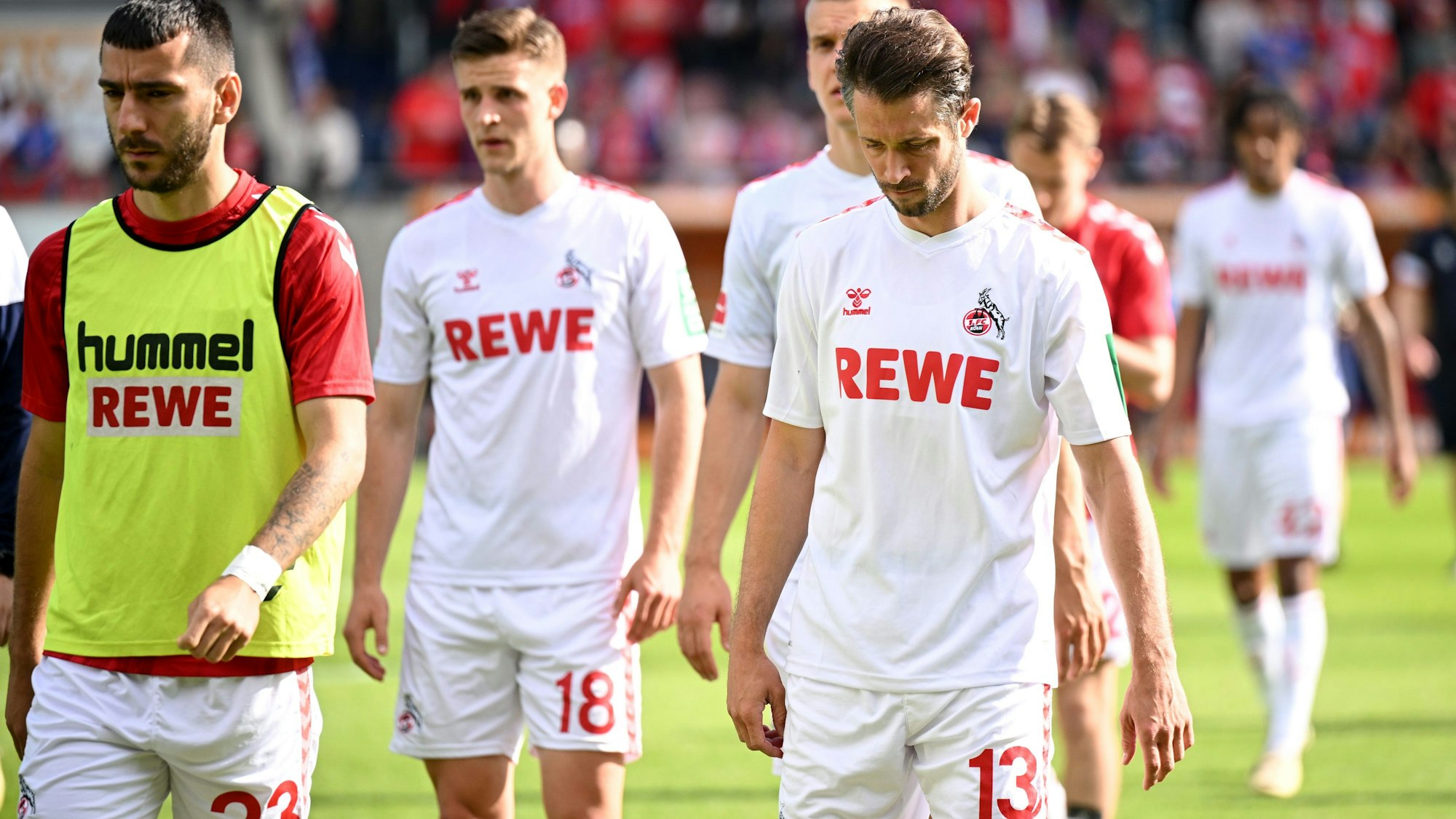 Die Kölner Spieler gehen nach der Niederlage geknickt vom Rasen.