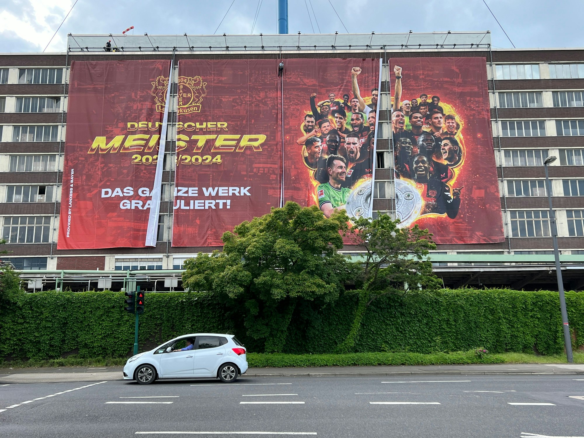 Noch während das Spiel läuft, lässt Lanxess ein Großplakat an der Bundesstraße 8 unterm Bayerkreuz austauschen: „Deutscher Meister 2023/2024“.