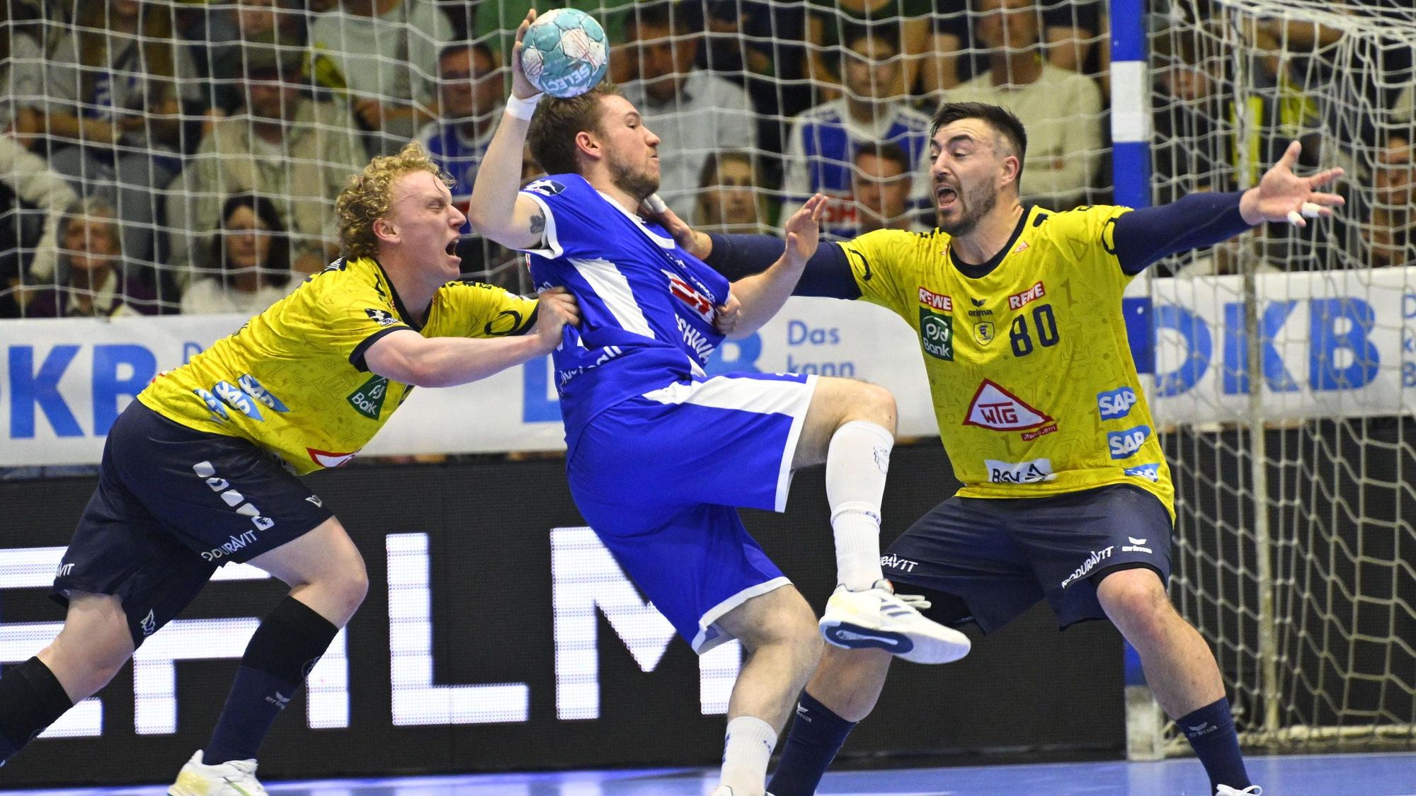 VfL-Spieler Dominik Mappes setzt sich in einem Handballspiel gegen die Abwehr der Rhein-Neckar Löwen durch.