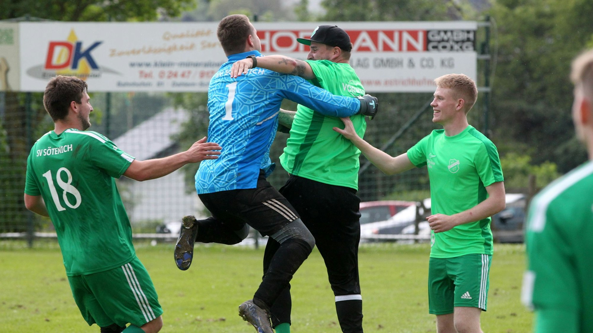 Ein Torwart springt seinem Trainer jubelnd in die Arme.