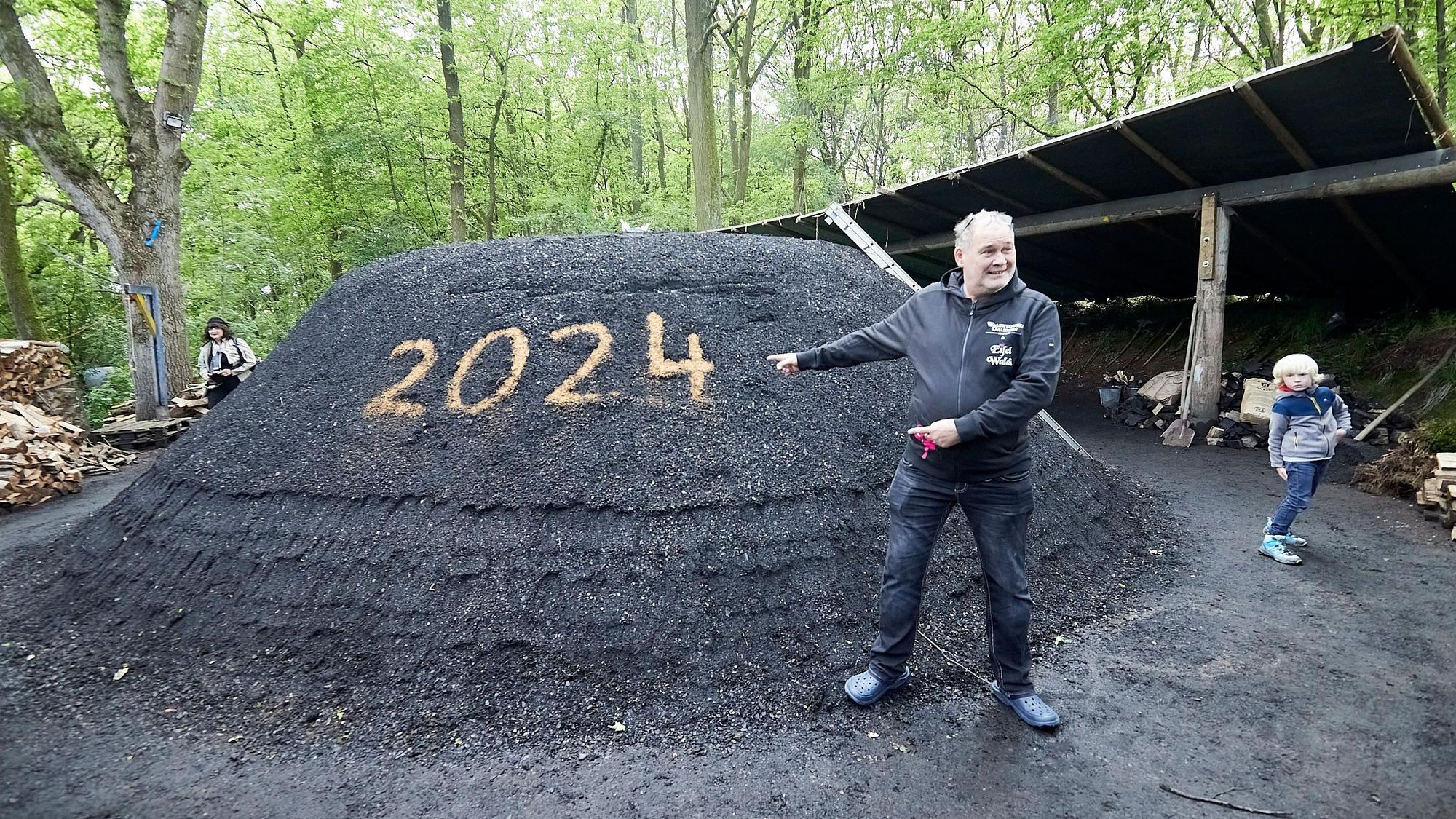Walter „Waldi“ Lehnertz steht vor dem Holzmeiler in Düttling.