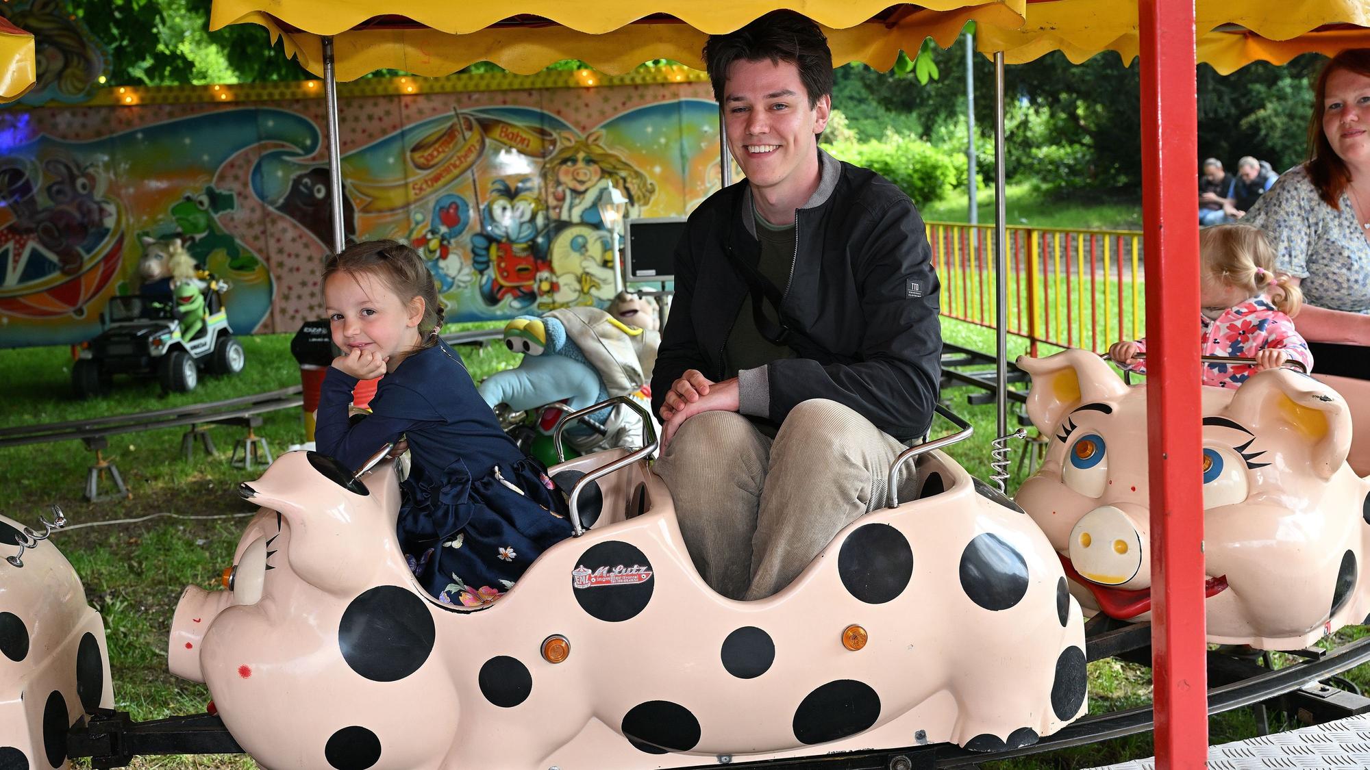 Ein junger Zeitungsreporter sitzt in der Schweinchenbahn.
