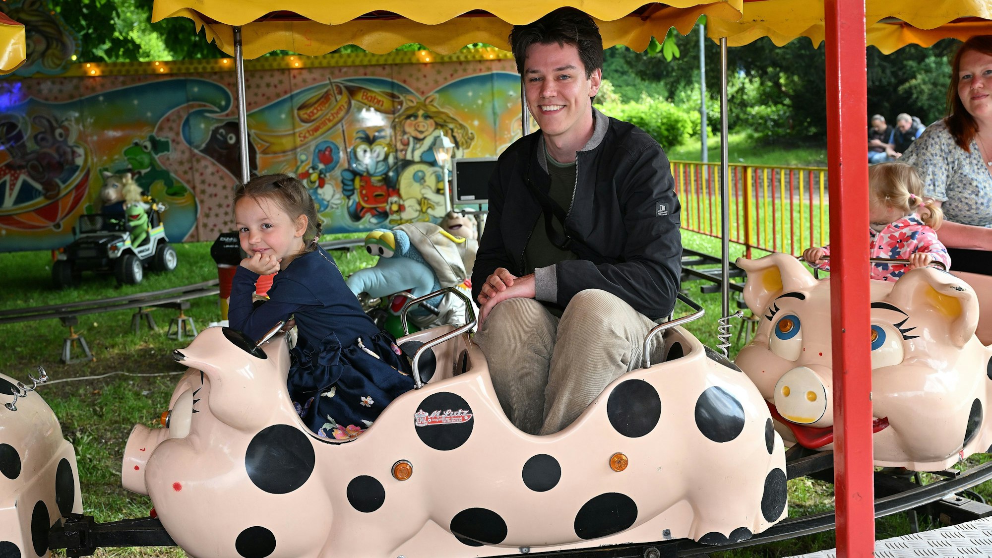 Ein junger Zeitungsreporter sitzt in der Schweinchenbahn.