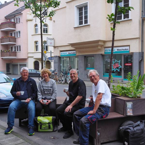 Karsten Heppner vom Bürgerverein Bayenthal-Marienburg, Sabine Müller, Matteo Specchio und Bodo Schmitt testen schon einmal das Kaffeetrinken auf Baum-Sitzbänken vor der Eisdiele.