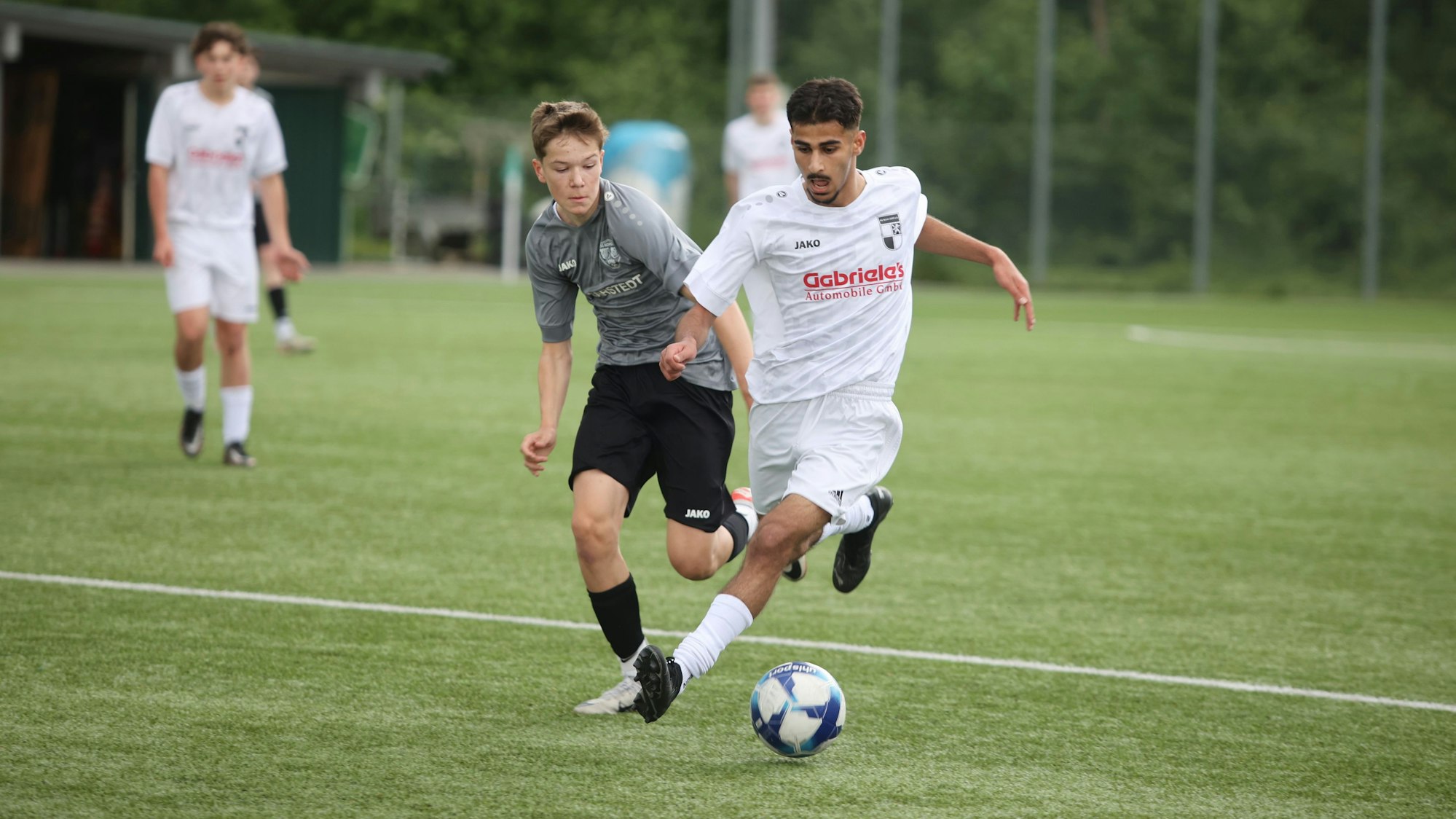 Eine Spielstation zweier Jugendteams auf einem Fußballplatz.