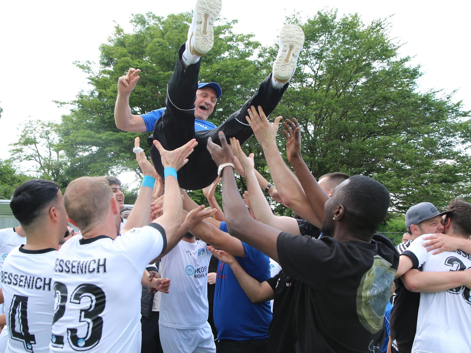 Fußballer lassen ihren Teammanager hochleben.