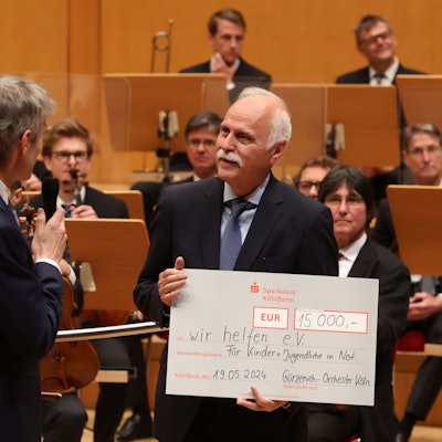 Karl-Heinz Goßmann hält einen großen Scheck in der Hand und freut sich darüber.