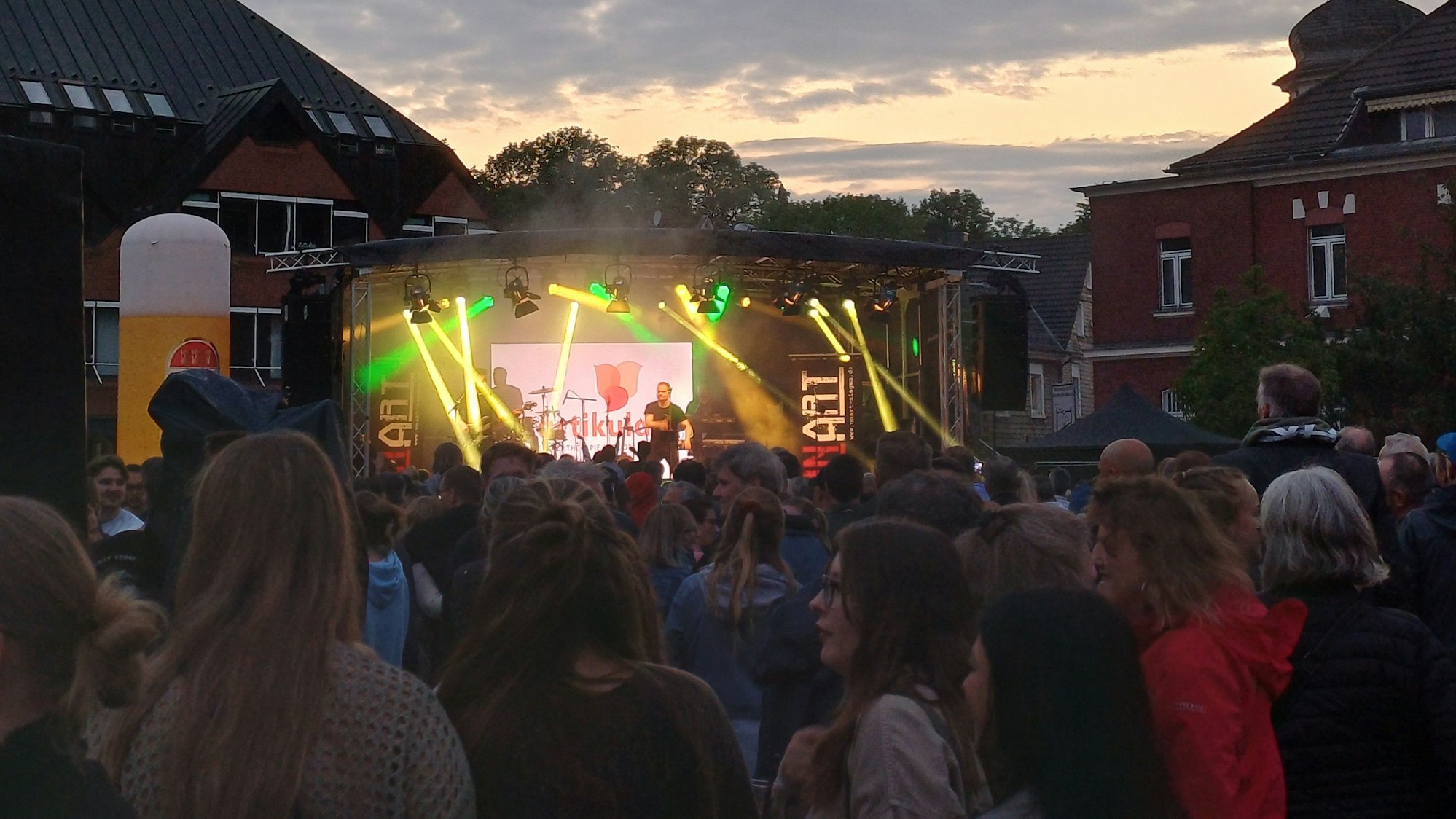 Menschen stehen vor einer Bühne mit Musikern im Leichlinger Stadtpark.