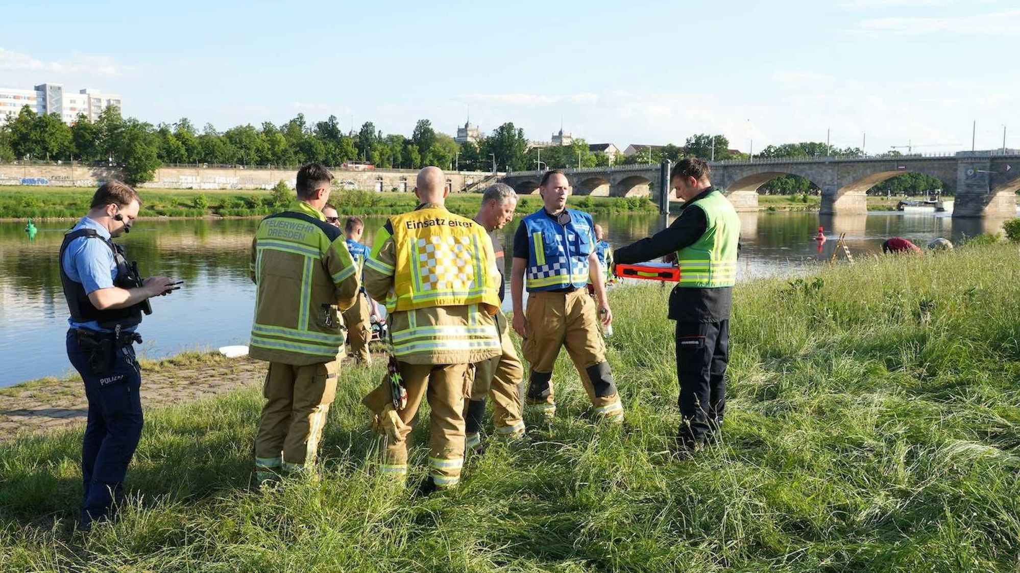 dpatopbilder - 20.05.2024, Sachsen, Dresden: Rettungskräfte stehen am Elbufer. Bei einem Blitzeinschlag sind zehn Menschen teils schwer verletzt worden, teilte die Feuerwehr mit. Zu dem Blitzeinschlag kam es bei den Elbwiesen im Bereich Rosengarten, wie es hieß. Foto: Benedict Bartsch/xcitepress/dpa +++ dpa-Bildfunk +++