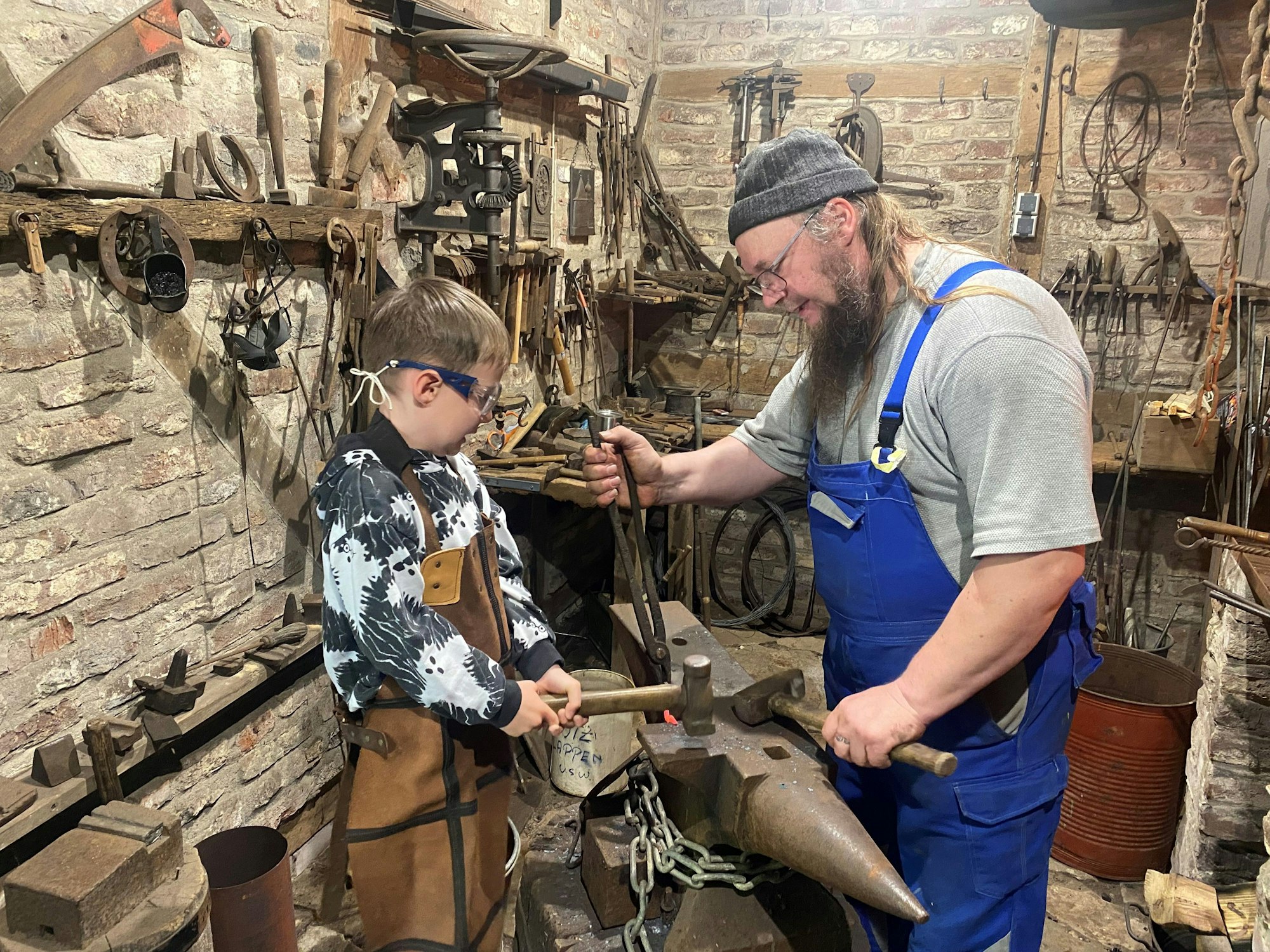 Finn ist ganz interessiert am Handwerk von Schmied Elle.