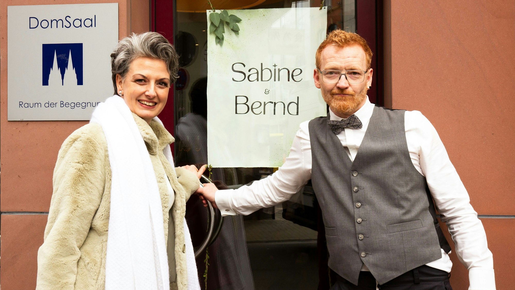 Das Paar vor dem Bestattungshaus Kuckelkorn
