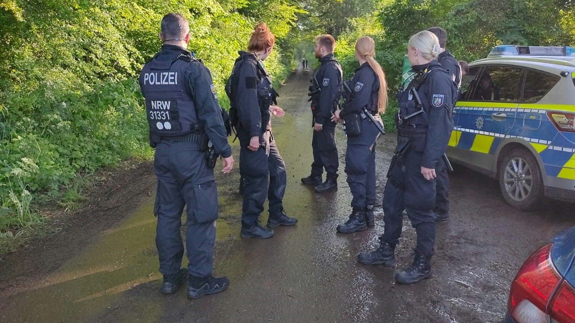 Das Bild zeigt sechs Polizistinnen und Polizisten, die auf einem Wirtschaftsweg stehen.