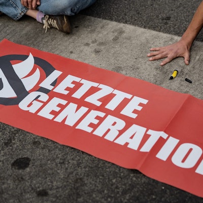 ARCHIV - 16.05.2022, Niedersachsen, Göttingen: Ein Aktivist der Gruppe «Letzte Generation», der seine Hand selbst auf der Straße festgeklebt hat, blockiert eine Kreuzung am Geismar Tor.