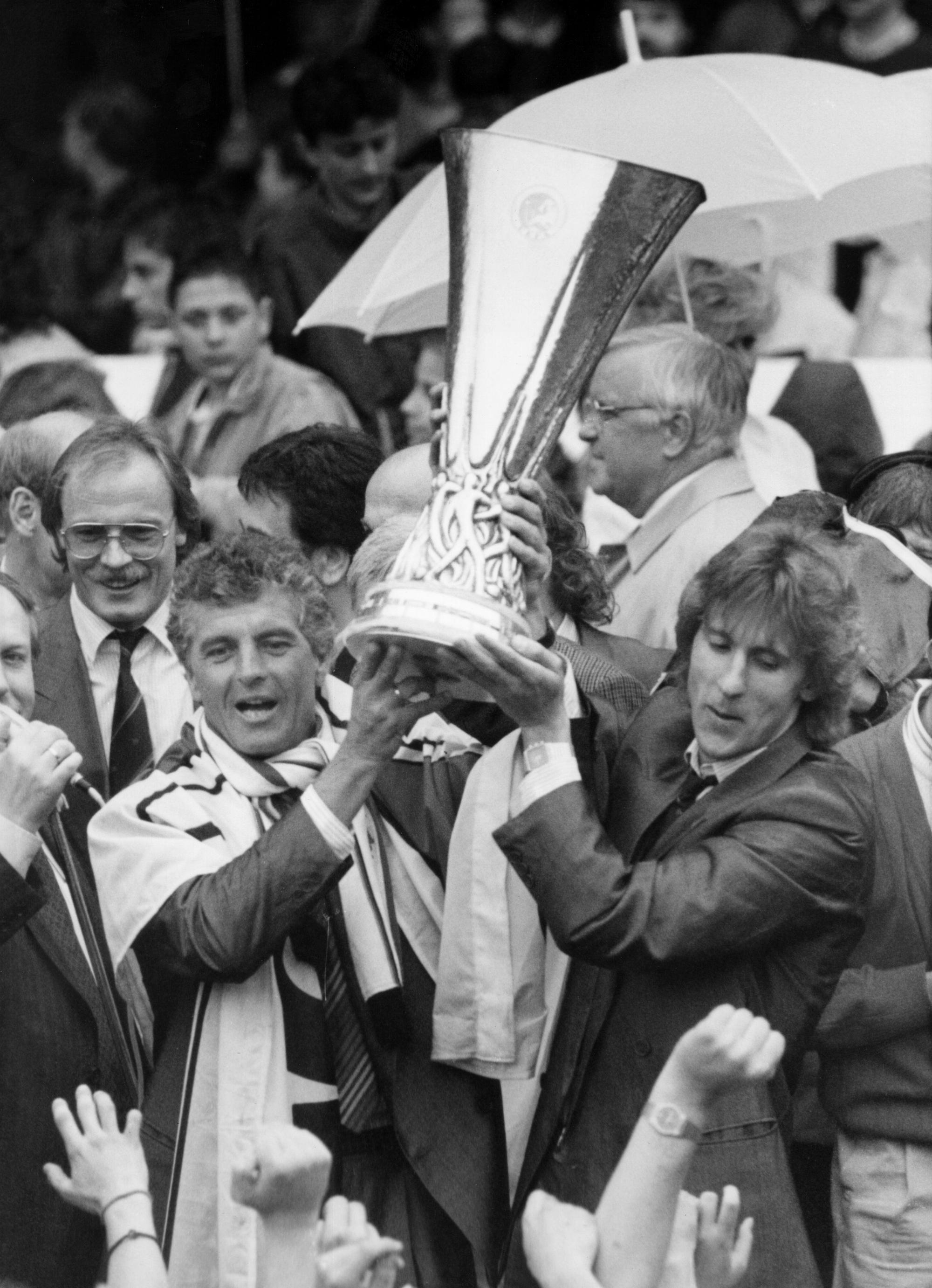 Erich Ribbeck (l), der Trainer von Bayer Leverkusen, hebt am 19. Mai 1988 in Leverkusen triumphierend den UEFA-Cup hoch.