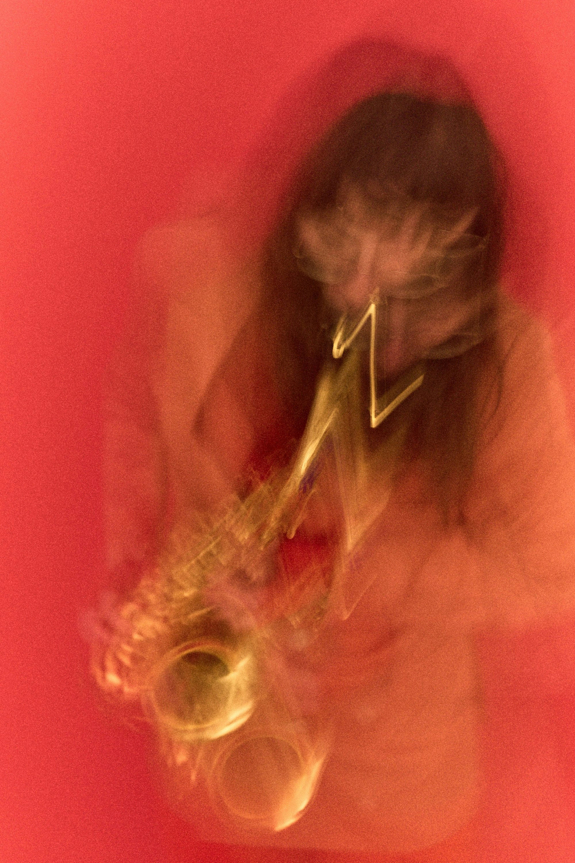 Musiker-Porträt: Saxophonist mit rotem Hintergrund