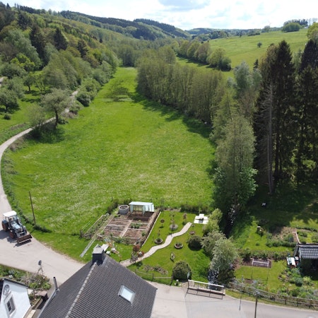 Das Luftbild zeigt eine grüne Wiese in einem Tal oberhalb von Golbach, wo Hochwasser-Schutzflächen entstehen sollen.