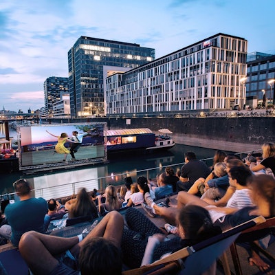 Menschen sitzen auf den Treppen im Rheinauhafen