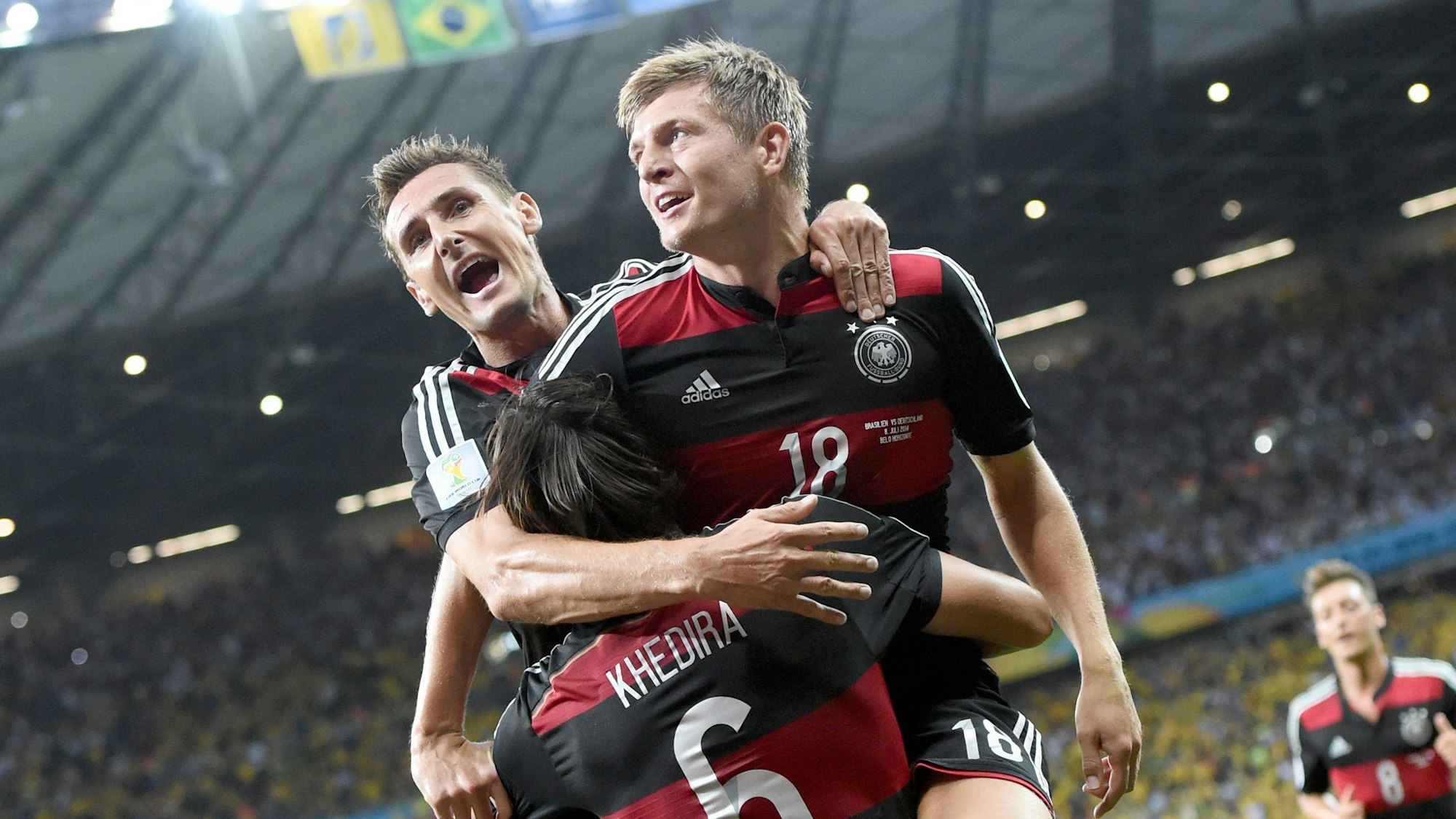 ARCHIV - 08.07.2014, Brasilien, Belo Horizonte: 08.07.2014, Brasilien, Belo Horizonte: Toni Kroos (r) aus Deutschland freut sich zusammen mit seinen Mannschaftskameraden Miroslav Klose (l) und Sami Khedira nach dem Tor zum 0:4. Deutschland schlug im Halbfinale der WM 2015 Brasilien mit 1:7.