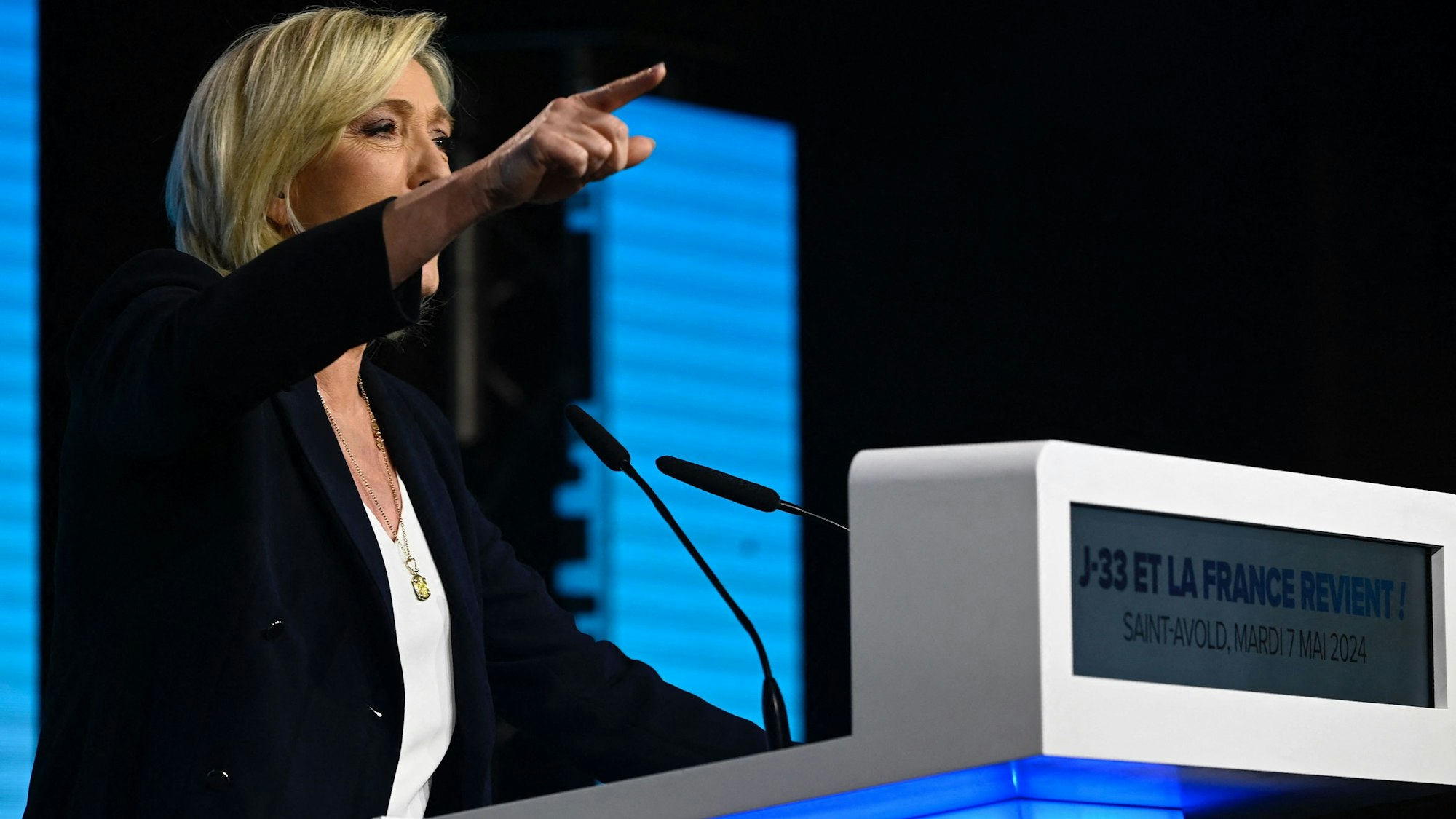 Marine Le Pen hält eine Rede und zeigt mit dem Finger in das Publikum.