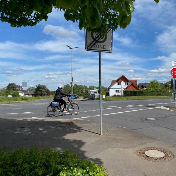 Eine Radfahrerin fährt über eine Kreuzung.