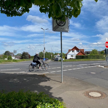 Eine Radfahrerin fährt über eine Kreuzung.
