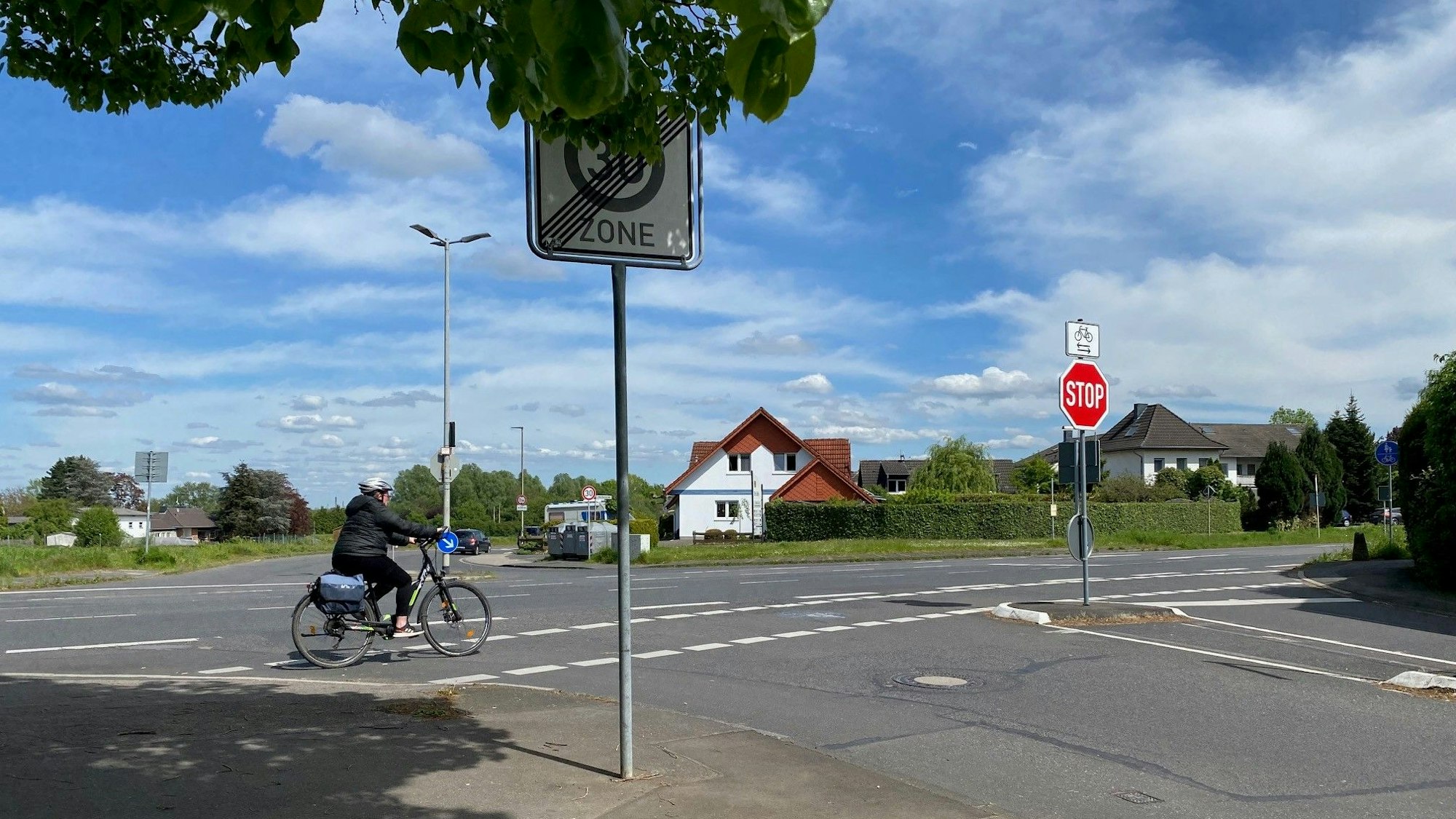 Eine Radfahrerin fährt über eine Kreuzung.