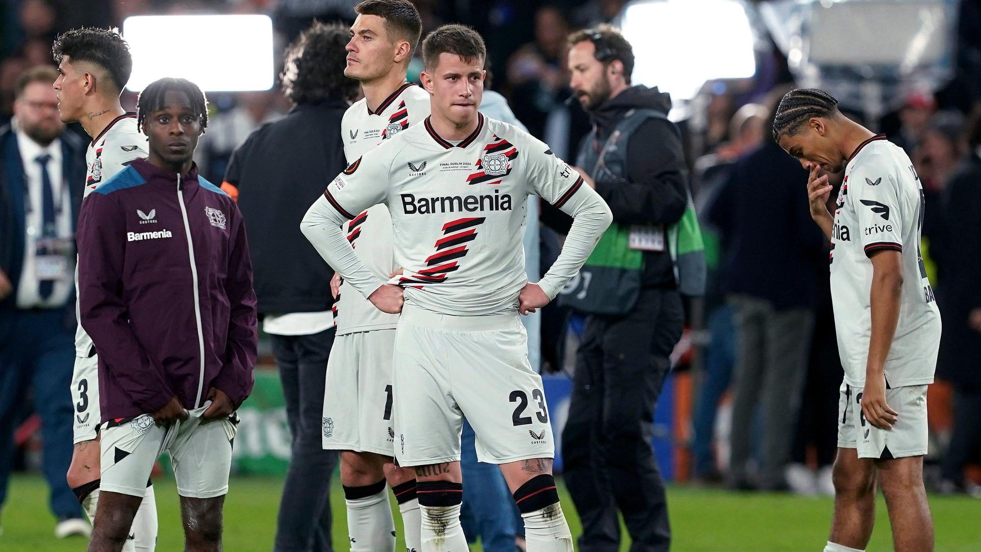 Bayer Leverkusen's Jeremie Frimpong, Adam Hlozek and Amine Adli, from left, react after the team's Europa League final against Atalanta on Wednesday May 22, 2024, in Dublin, Ireland. (Brian Lawless/PA via AP)