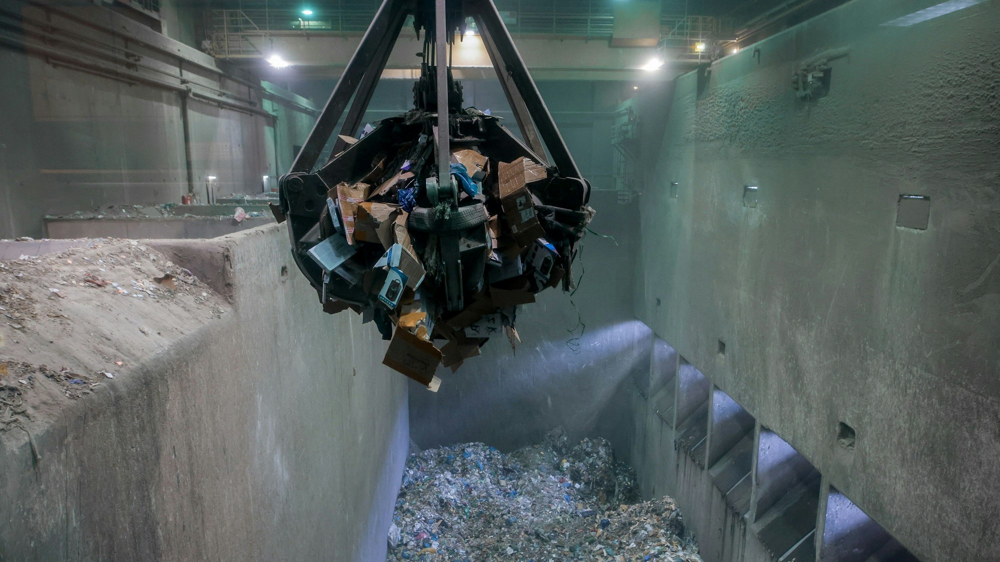 16.11.2022, Köln: Reportage Zigarettenschmuggel mit dem Zoll in Köln - Ein Kran transportiert Pakete mit geschmuggelten Zigaretten in der Müllverbrennungsanlage Weisweiler in Eschweiler. Foto: Thilo Schmülgen