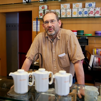 Ein Mann steht hinter eine Theke.