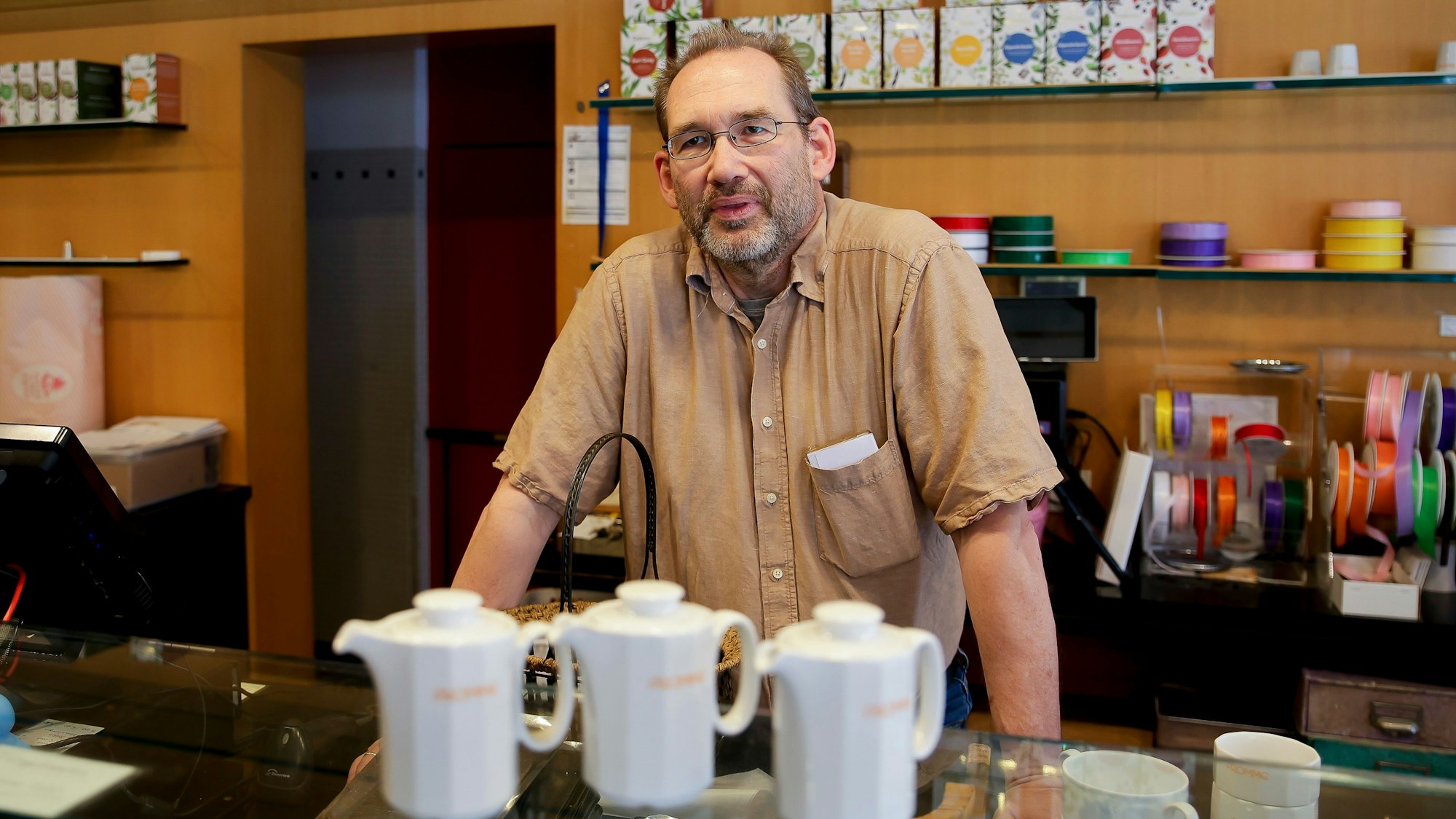 Ein Mann steht hinter eine Theke.