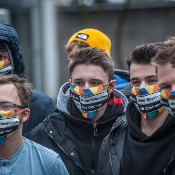 Schüler des Berufskollegs in Leverkusen-Opladen tragen eine bunte Maske mit der Aufschrift„ Schule ohne Rassismus. Schule mit Courage.“