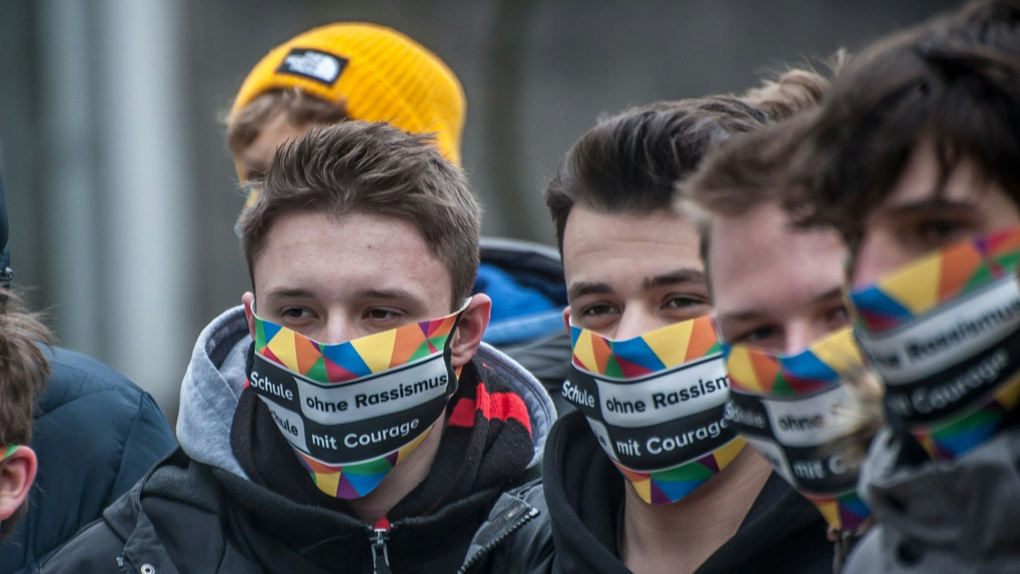 Schüler des Berufskollegs in Leverkusen-Opladen tragen eine bunte Maske mit der Aufschrift„ Schule ohne Rassismus. Schule mit Courage.“