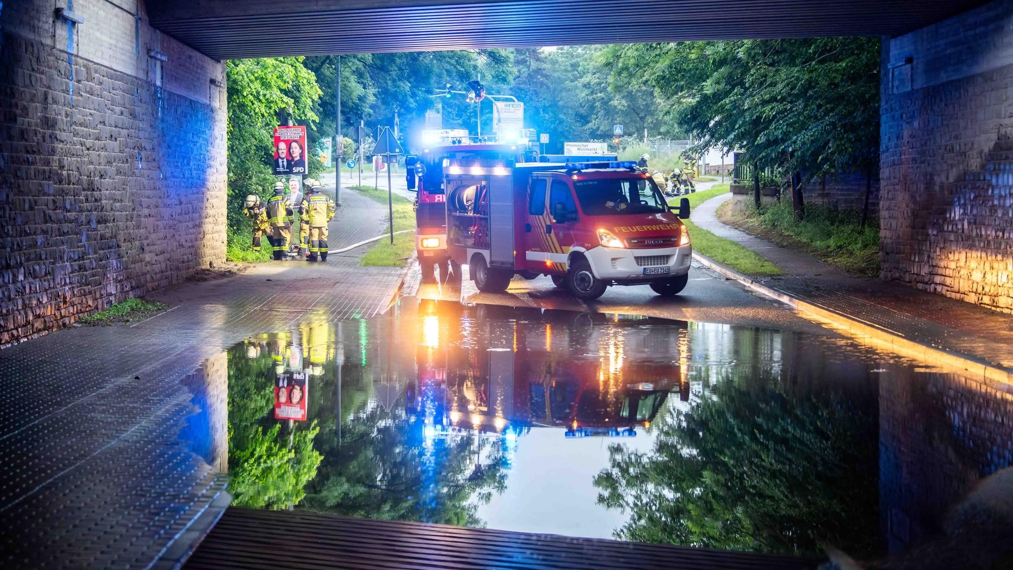 Das Bild zeigt die überflutete Unterführung. Im Hintergrund stehen zwei Feuerwehrfahrzeuge.
