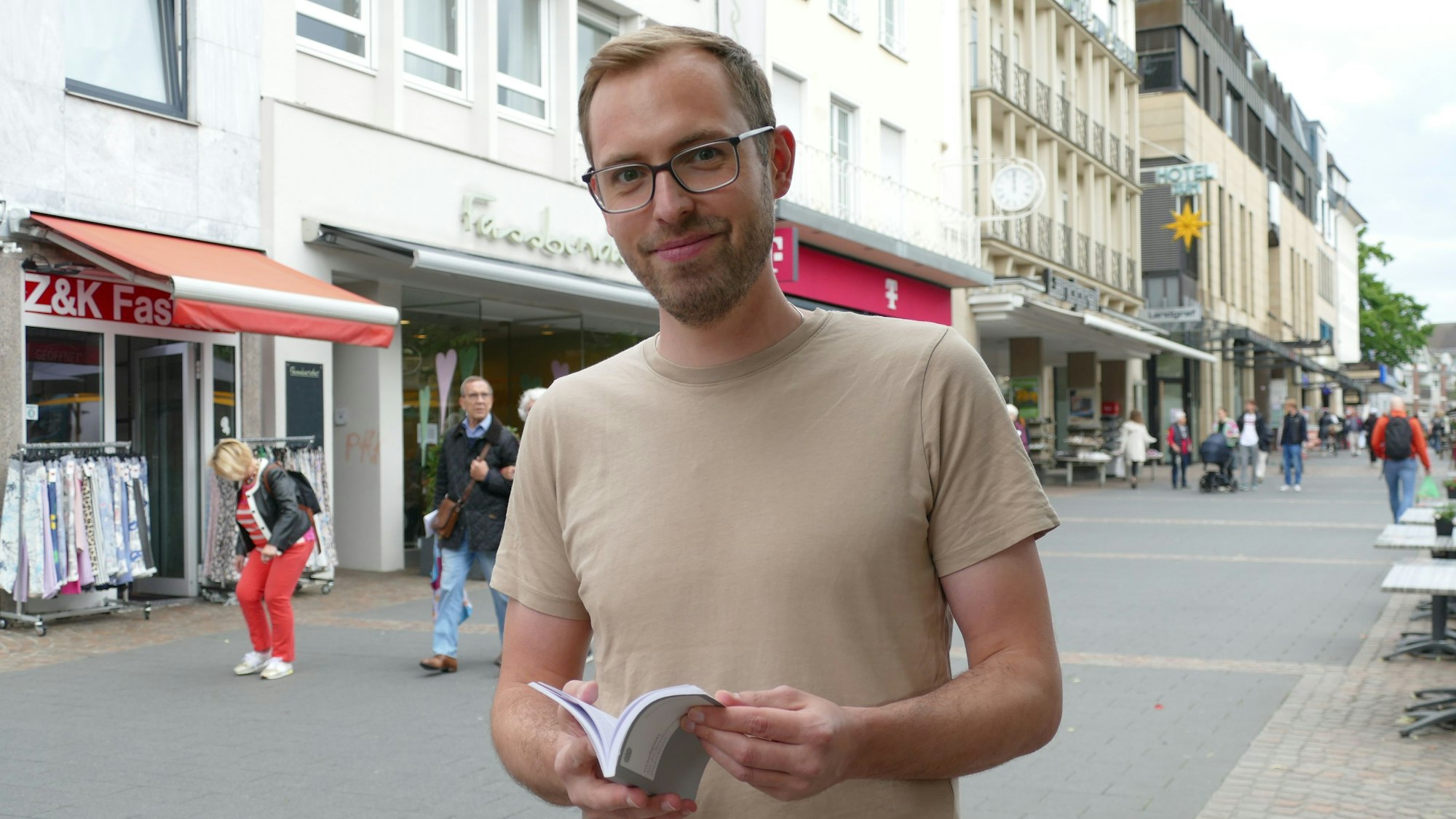 Ein Mann hält ein Grundgesetz in der Hand.