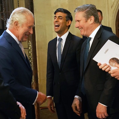 Rishi Sunak lacht zwischen Politikern.