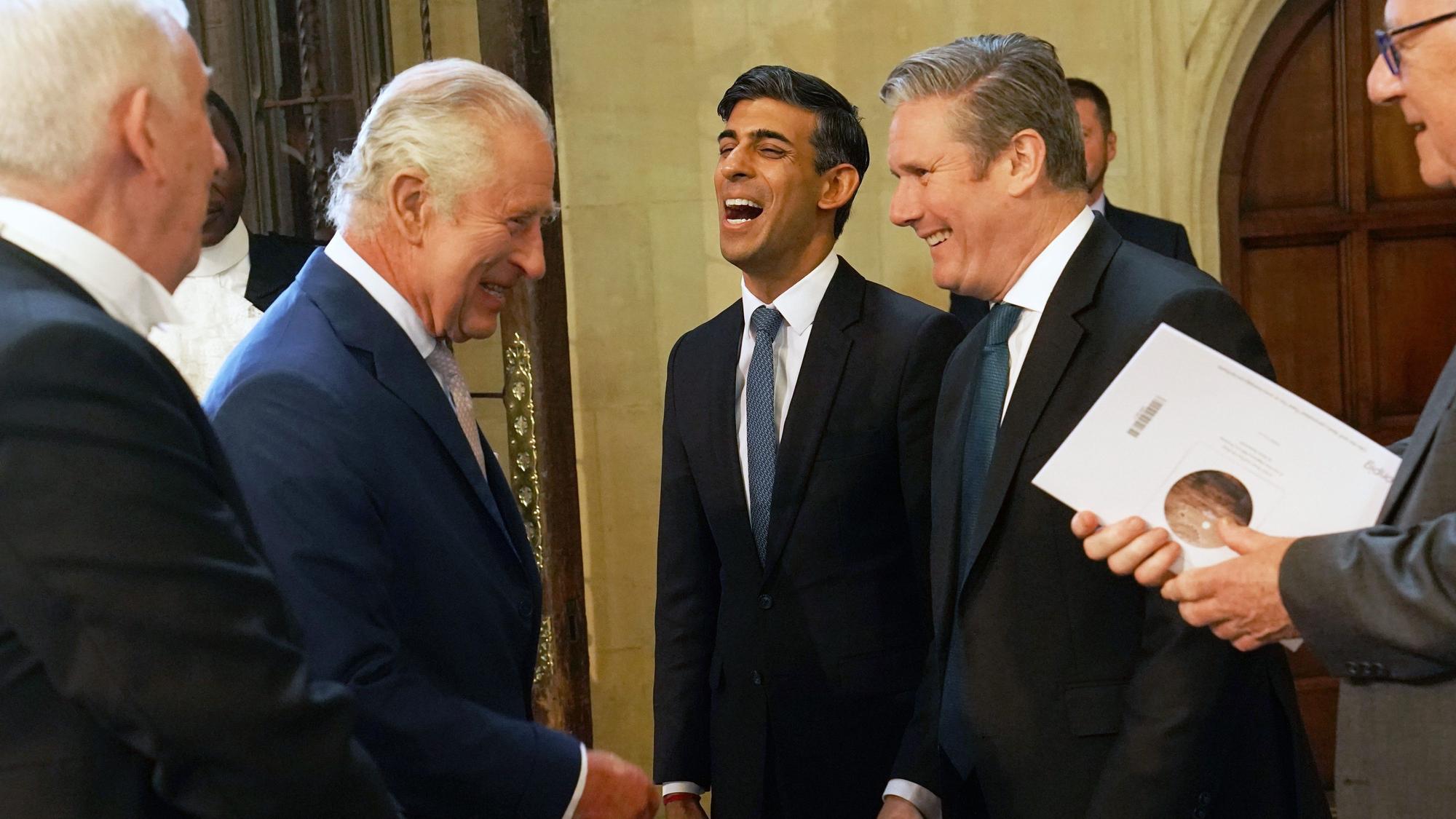 Rishi Sunak lacht zwischen Politikern.