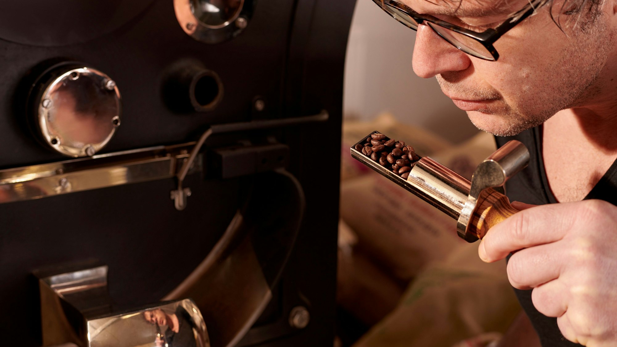 Eine Person riecht an gerösteten Kaffeebohnen.