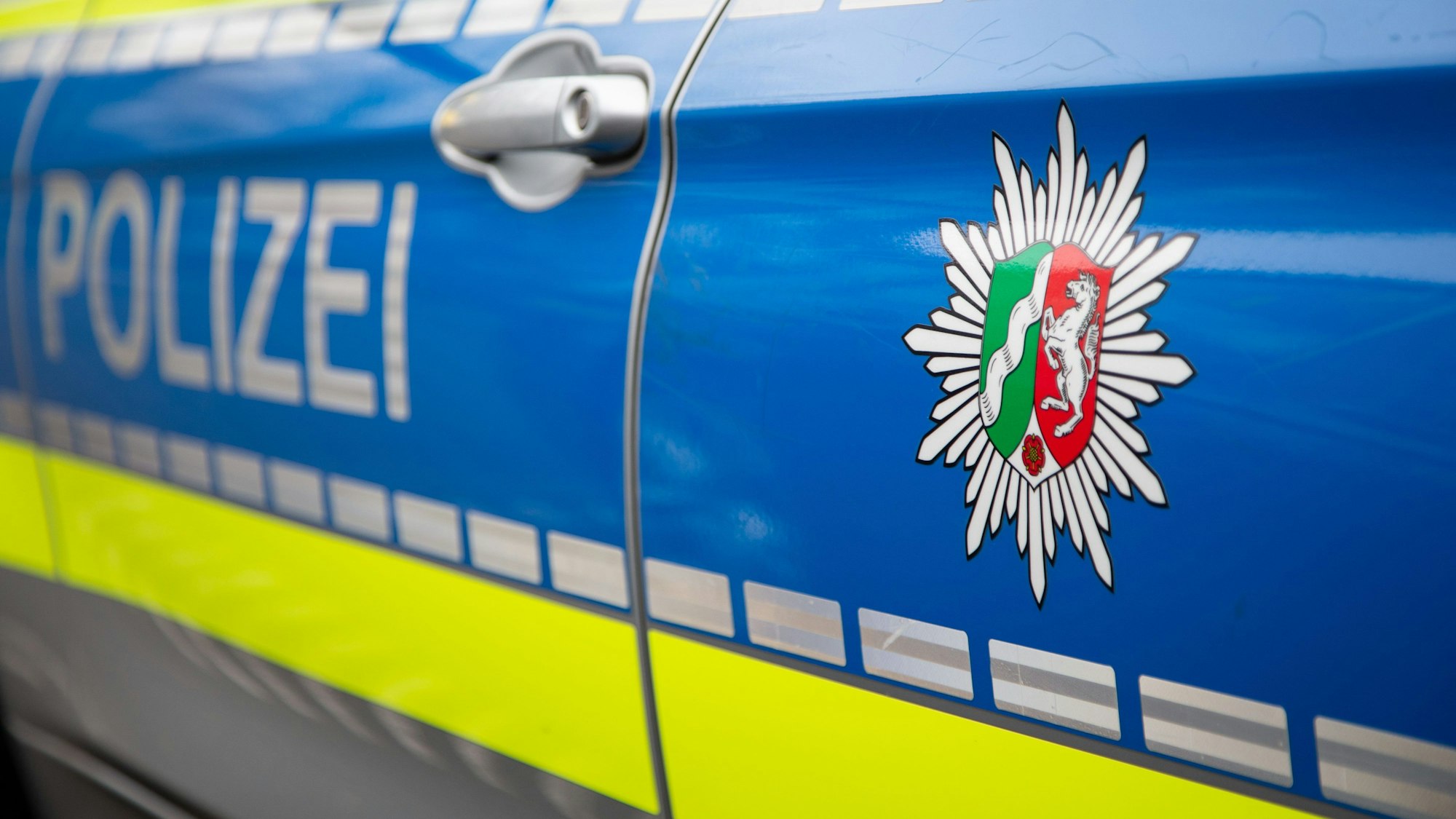 Blick auf ein Emblem der Polizei in NRW an einem Polizeiauto.