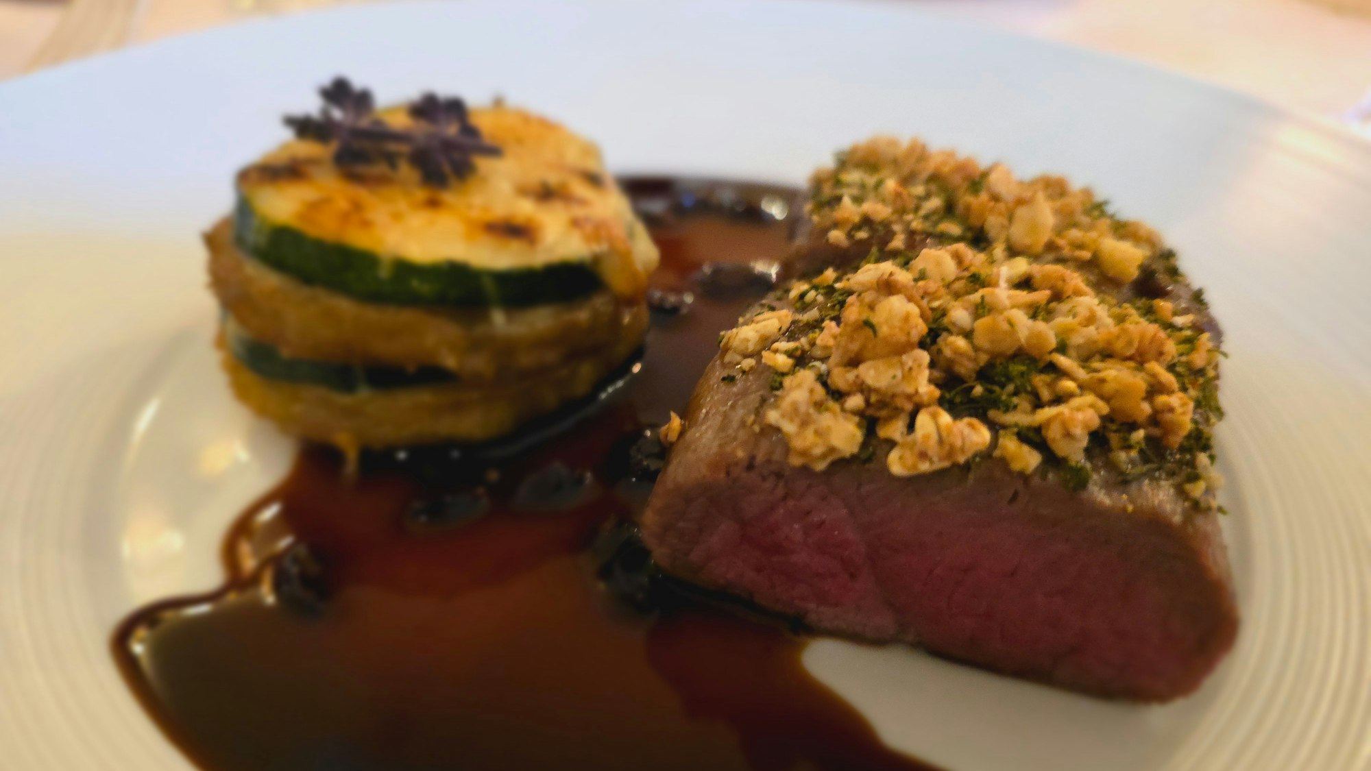 Teller mit Lammrücken und Moussaka-Gemüse