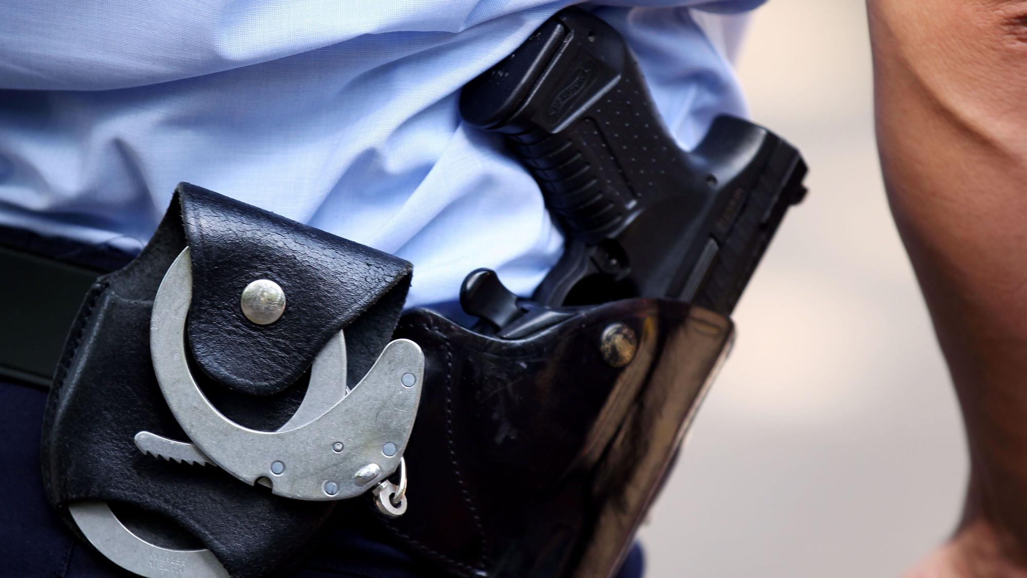 Ein Polizist mit Handschellen und Pistole am Gürtel.