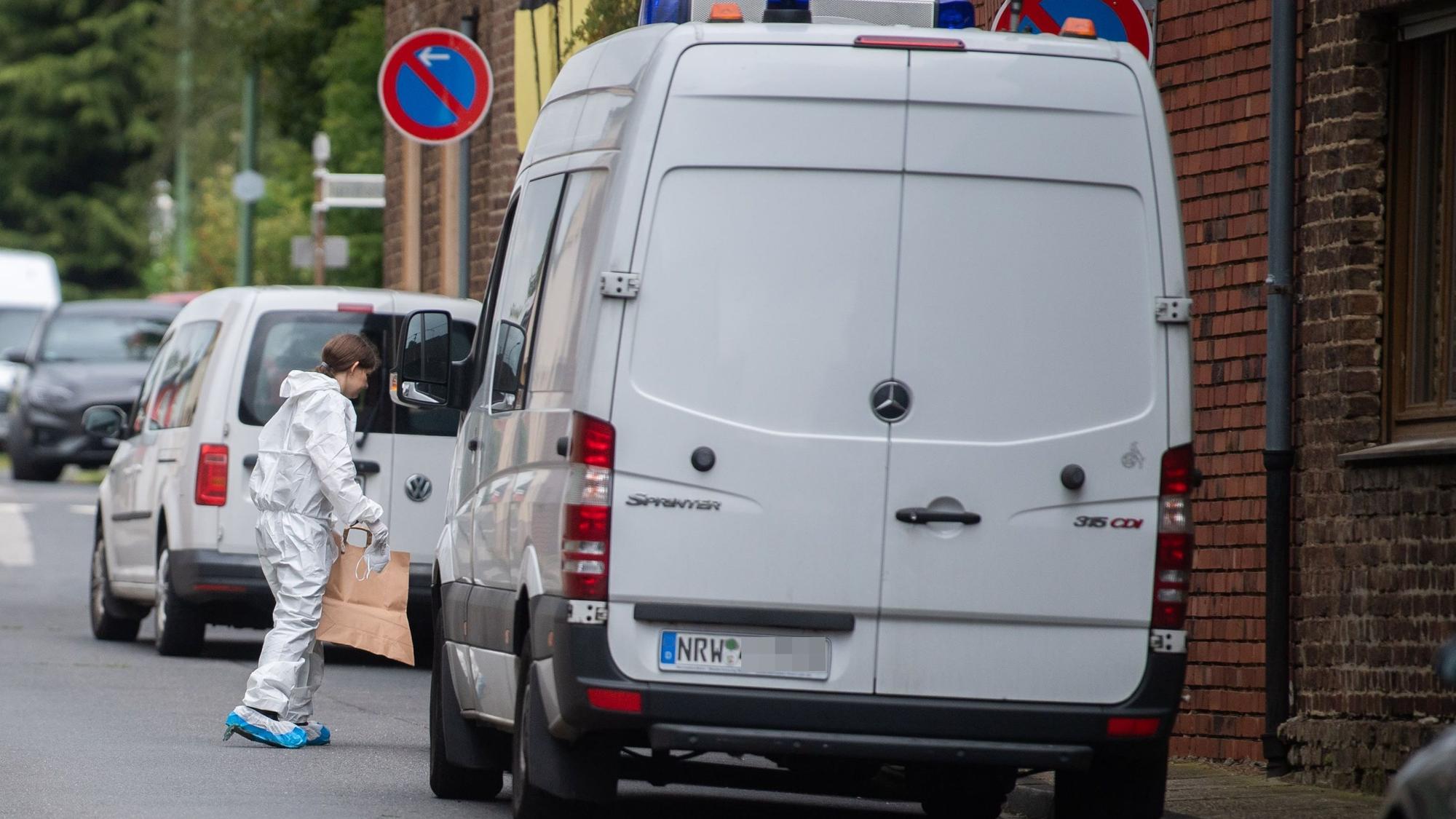 Das Bild zeigt eine Beamtin der Bonner Mordkommission am Tatort in Füssenich. Sie trägt eine Papiertüte in das Gebäude.