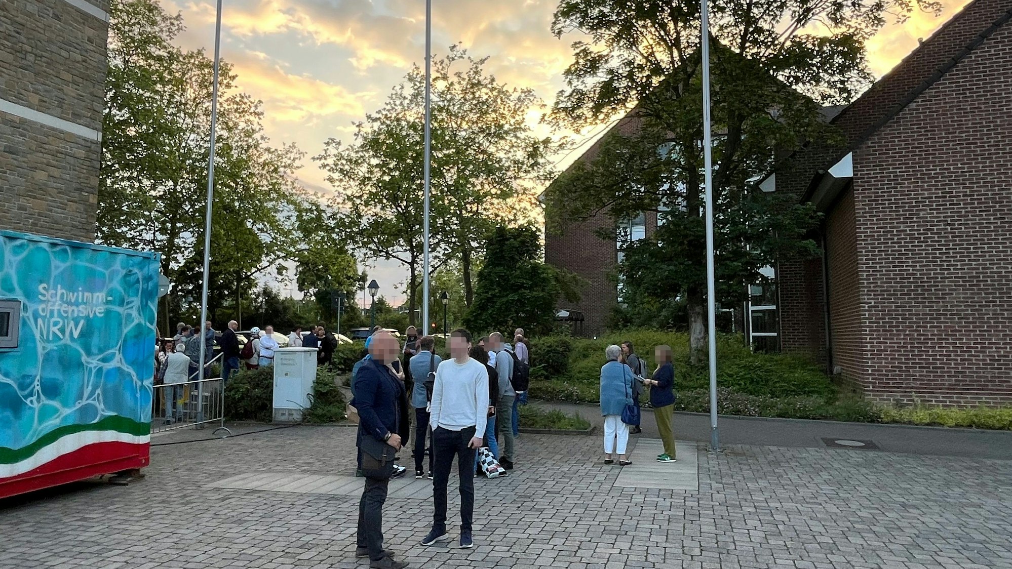 Teilnehmende der Sitzung des Umweltausschusses warteten während des Einsatzes außerhalb des Rathauses.