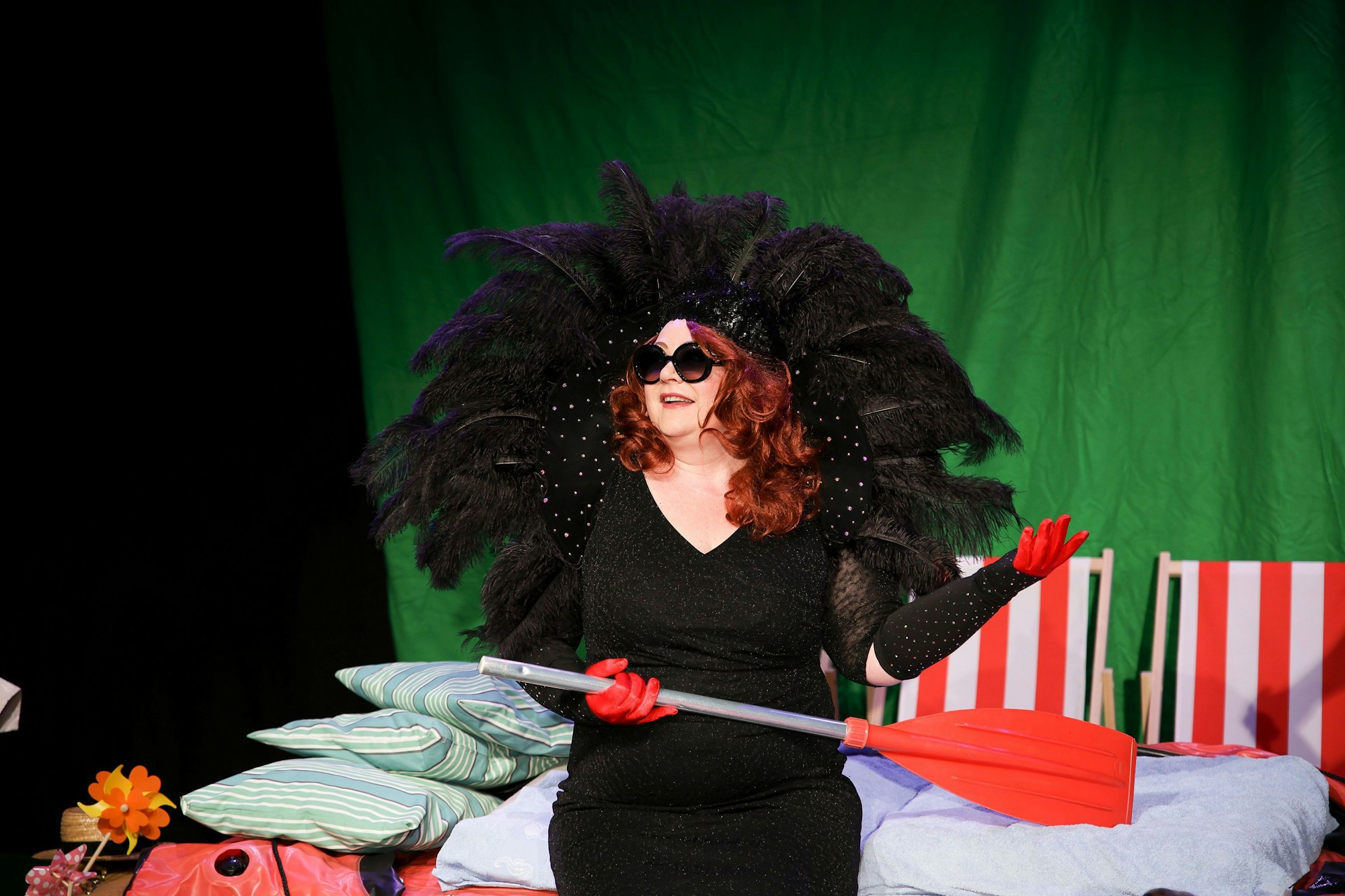 Natascha Balzat mit großem Federkopfschmuck und Ruder in der Hand.