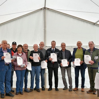 16 Männer und Frauenhaben sich zum Gruppenbild aufgestellt.