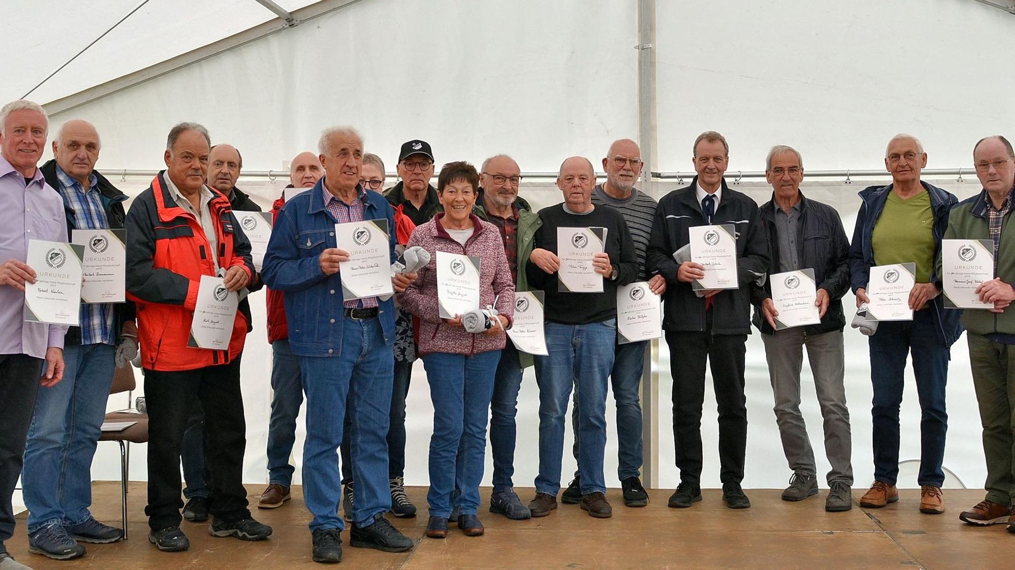 16 Männer und Frauenhaben sich zum Gruppenbild aufgestellt.