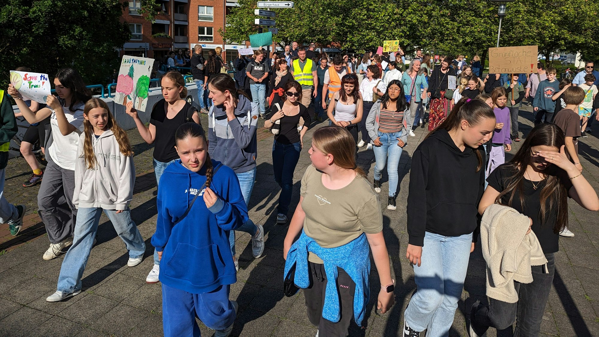 Ein Protestzug von Schülerinnen und Schülern mit Plakaten auf dem Plat vor dem Bürgerhaus.
