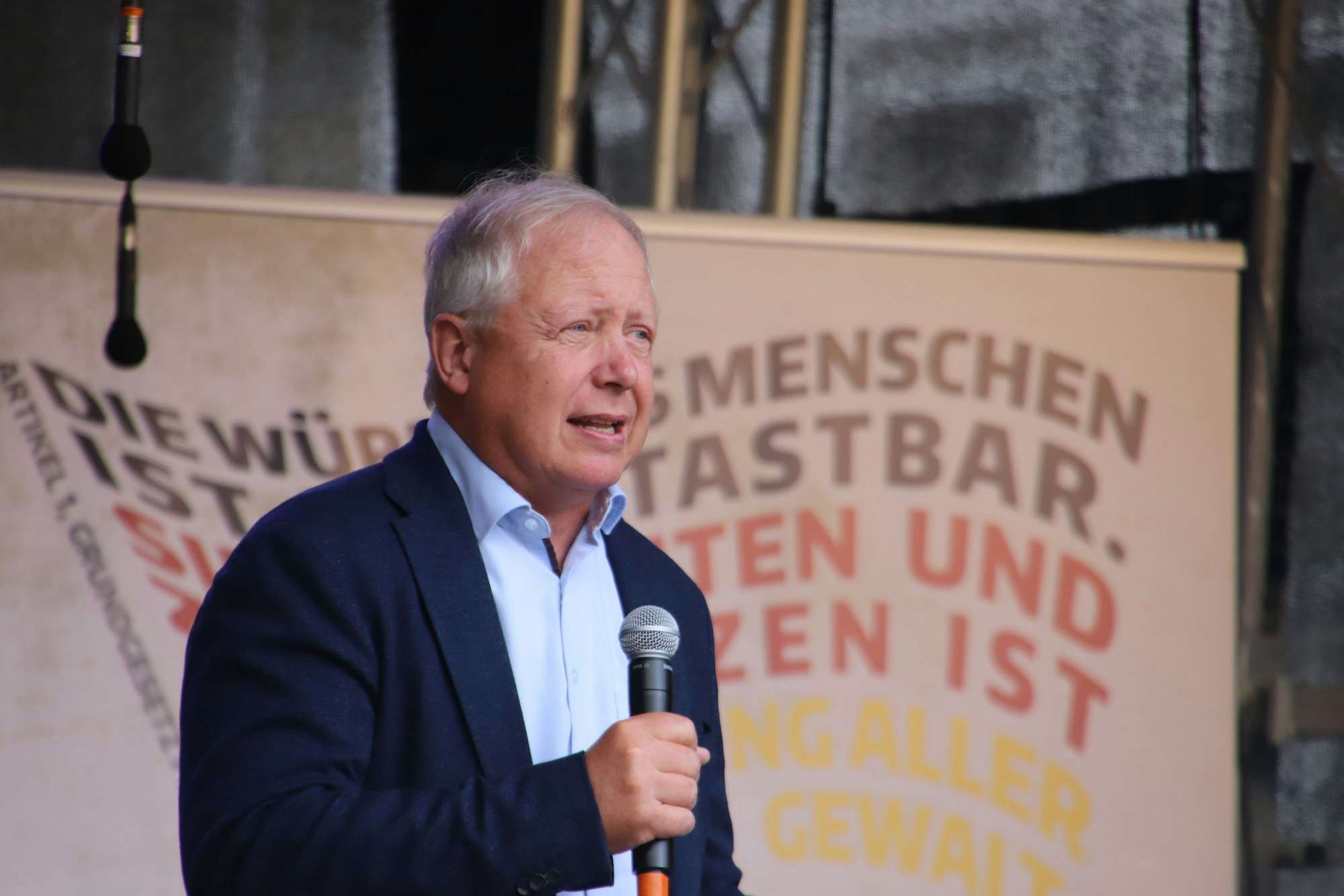 WDR-Intendant Tom Buhrow hat ein Mikrofon in der Hand und hält eine Rede.