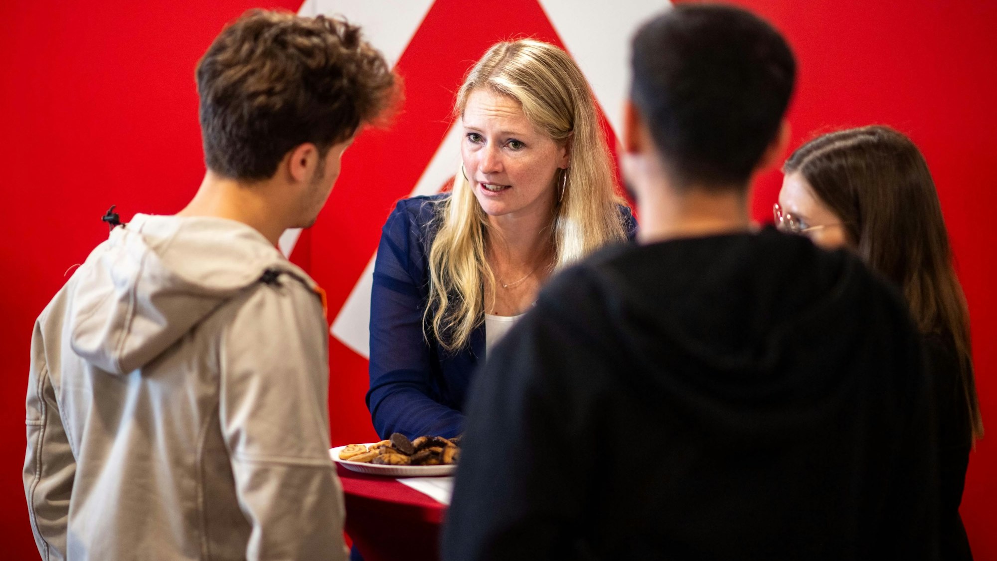 Das Bild zeigt eine Mitarbeiterin des Jobcenters im Gespräch mit einem jungen Mann.