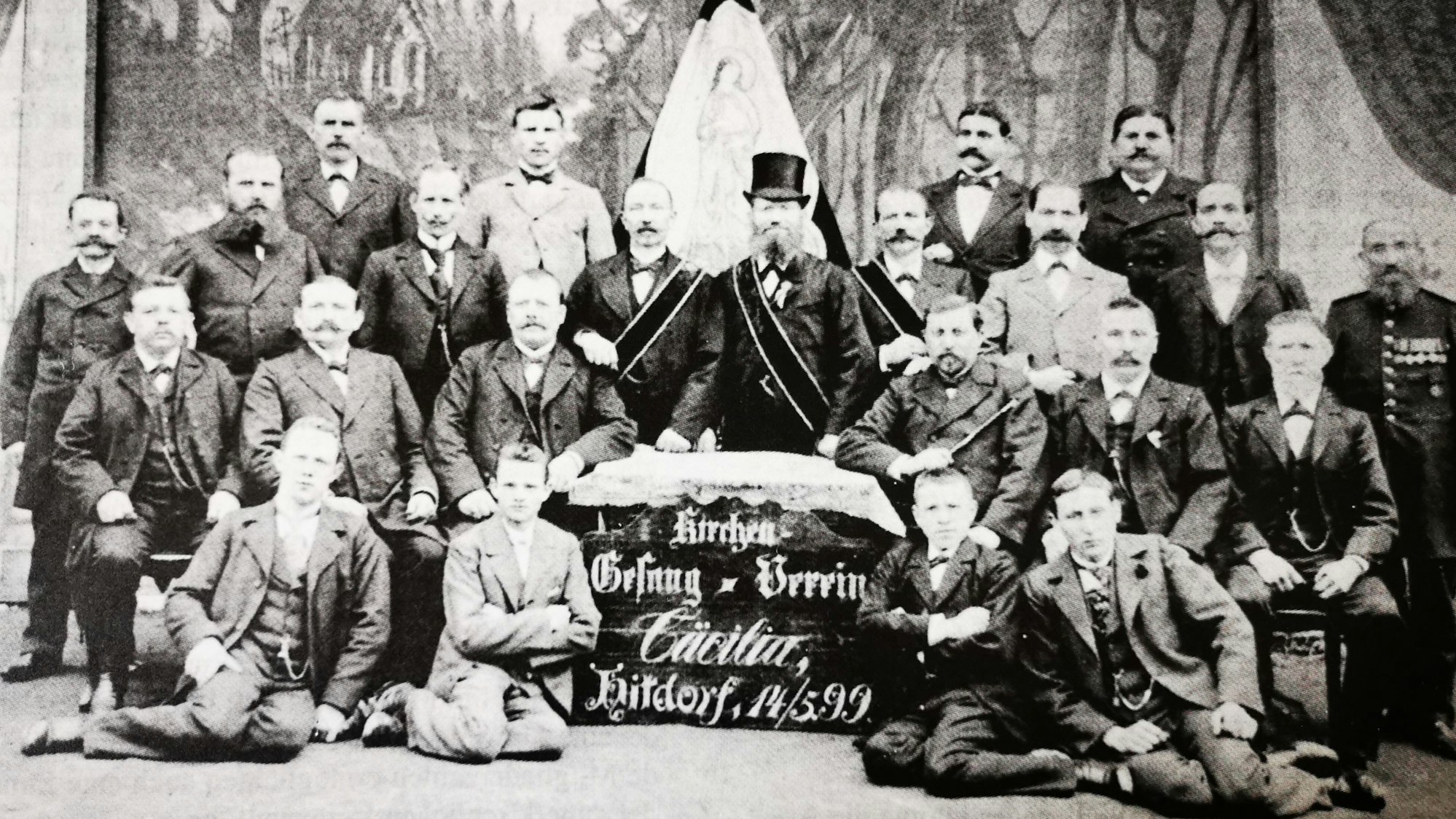 Etwa 20 Männer in feiner Kleidung Kleidung posieren für ein Foto.